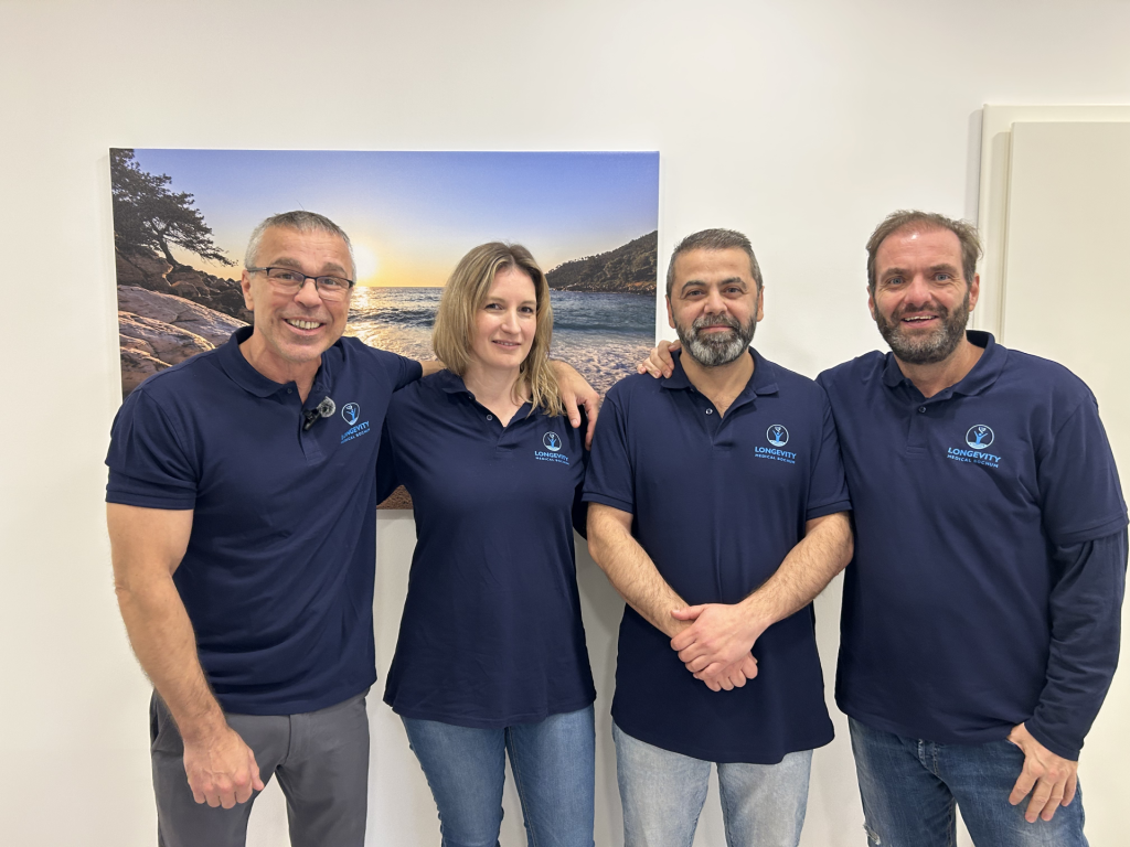 Vier Personen posieren lächelnd zusammen